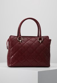 Sac à main matelassé bordeaux avec cuir verni, double poignées supérieures et accents métalliques argentés sur les anneaux et la fermeture éclair.