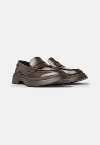 Braune Lederloafers mit einer strukturierten Sohle, ausgestattet mit einem breiten, flachen Riemen über dem Obermaterial und dezenten Steppnähten.