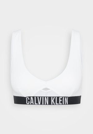 Weißes, geripptes Baumwoll-Bralette mit einem schwarzen elastischen Band mit "CALVIN KLEIN"-Logo. Es hat einen V-Ausschnitt und einen Rückenausschnitt.