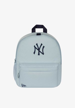 Lysegrå rygsæk med lynlåslomme foran, netlomme i siden, sort New York Yankees-logo og sort håndtag på toppen.