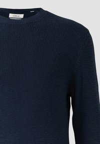 Granatowy sweter o prążkowanej fakturze, okrągłym dekolcie i długich rękawach. Posiada subtelny metkę przy kołnierzu.