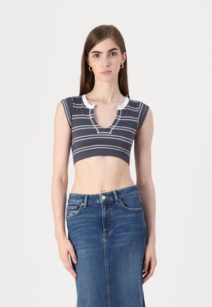 Crop top rayé gris avec col blanc ; texture côtelée et manches courtes associé à une jupe midi en denim. Design simple et fonctionnel.