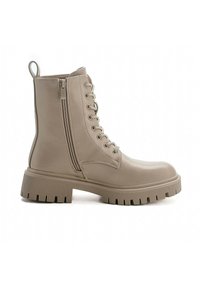 Stivali ankle beige in materiale sintetico liscio con suola a dente chunky, zip laterale e lacci frontalmente.