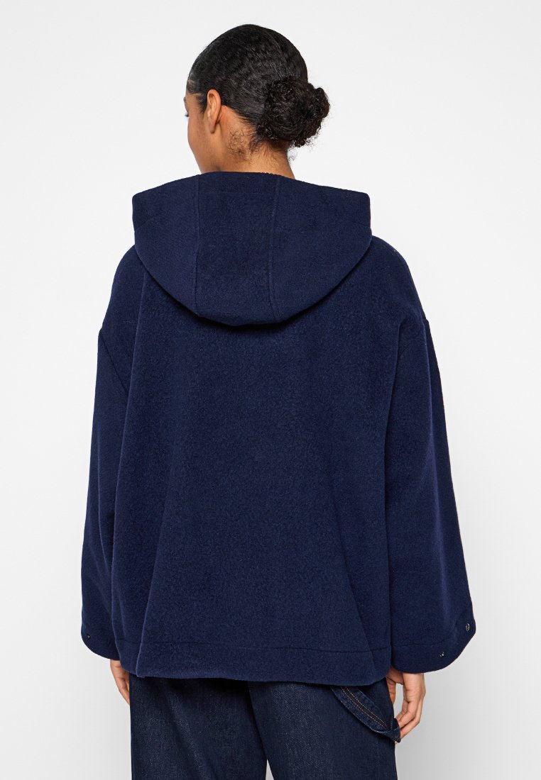 Navyblaue Wollmischung-Haubejacke mit lässigem Schnitt, weiten Ärmeln und Rückennahtdetails. Strukturierter Stoff mit weichem Finish.