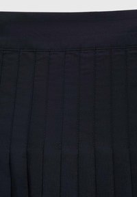 Tessuto plissettato nero con cuciture verticali; texture liscia; vita sopra le pieghe; colore uniforme senza motivi o decorazioni.