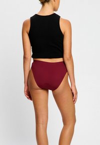 Top court noir et bas de bikini taille haute bordeaux, texture lisse, design ajusté et coutures minimales, vus de dos.