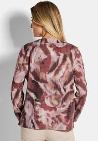 Langsleeve blouse met een multicolor abstract patroon in tinten bordeaux, roze en beige. Zachte stof met een relaxed fit.