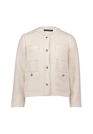 Veste en tweed texturé crème avec col rond, quatre poches avant et quatre boutons argentés sur le devant.