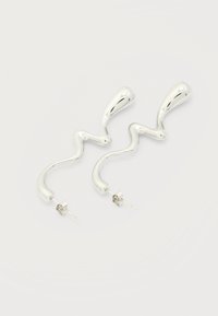 Ασημί αφηρημένα κυματιστά σκουλαρίκια με πινέζα κλεισίματος, σε απλό λευκό φόντο.