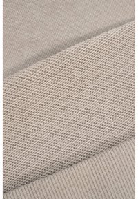 Dwie beżowe tekstury tkaniny umieszczone obok siebie: jedna to delikatny dżersej, a druga to grubszy, ryfnowany splot.