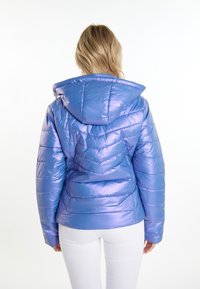 Jachetă albastră, lucioasă și pufosă, cu glugă, având modele de cusături orizontale și un design ajustat. Textură netedă și umplutură ușoară.