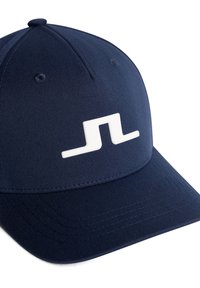 Cappellino da baseball blu navy realizzato in tessuto, con un logo in gomma bianca sulla parte anteriore. Il cappellino ha una corona strutturata e una visiera curvata.
