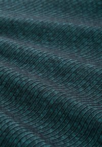 Textured fabric in deep teal, featuring wavy pattern and ridges. Material appears soft with a subtle sheen, enhancing visual depth.