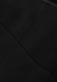 Čierny textil s hladkou textúrou, s našitými švami a jednoduchým dizajnom bez vzorov alebo ozdôb.