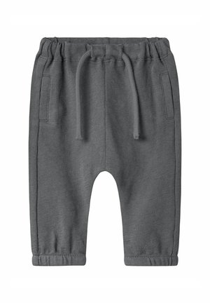Jogging en maille gris avec une taille élastique, cordon de serrage, deux poches latérales et poignets fuselés. Texture douce et coupe décontractée.