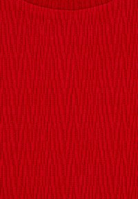 Textúrás piros szövet függőleges bordázott mintával, enyhe fényességgel. Sima, kötött textúra, lekerekített nyakkivágással a felső szélén.