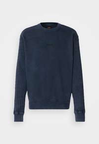 Granatowy sweter z okrągłym dekoltem, ozdobiony teksturowanymi rękawami i małym haftowanym logo 'BOSS' na piersi. Materiał mieszanka bawełny.