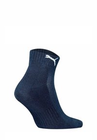 Calze alla caviglia blu realizzate in un tessuto con maglia testurizzata. Presentano un logo Puma bianco sul lato e un bordo a coste per una vestibilità aderente.