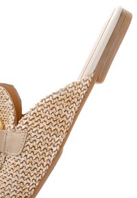 Zapato slip-on de color beige, tejido, con un upper texturizado, que cuenta con una suela plana y una tira decorativa a lo largo del empeine.