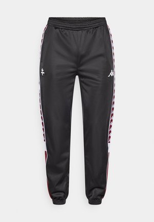 Black athletic pants with an elastic waistband. Features white side accents with a maroon pattern and logo on the front. Smooth, shiny fabric.