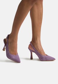 Escarpins slingback en daim violet avec un bout pointu et un talon stiletto moyen, dotés d'une bride de maintien et d'une texture lisse.