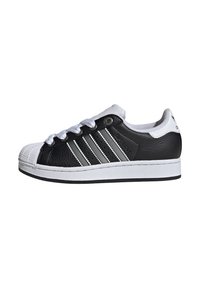 Black and white sneaker with a leather upper, rubber toe cap, three grey stripes on the side, and white laces. Flat sole design.