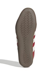 Röd idrottssko med sula som har ett zigzag-m�önster för grepp och tre vita ränder. Varumärket "adidas" pryntat nära hälen.