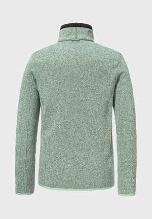Grüne strukturierte Jacke mit hohem Kragen, schwarzem Besatz und kontrastierenden grünen Nähten. 
