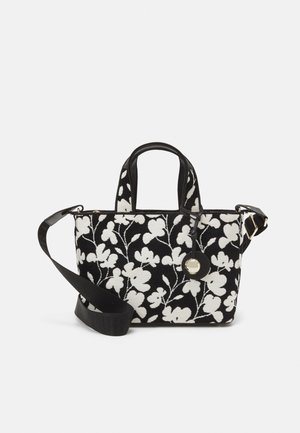 Sac à main floral noir et blanc, en tissu texturé avec un motif de fleurs brodé, doté de poignées doubles et d'une sangle épaule amovible.