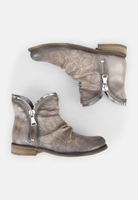 Botines de cuero gris suave con patrón floral perforado, presentan cremalleras plateadas y un tacón de madera bajo. Diseño texturizado y caído.