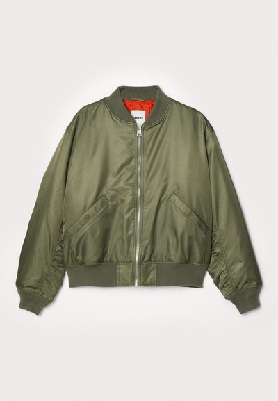 Chaqueta bomber verde oliva con cuello, puños y dobladillo acanalados, cremallera frontal, bolsillos inclinados con botón de presión y forro interior naranja brillante.