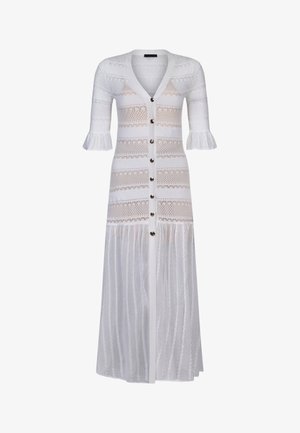 Abito lungo bianco in maglia con scollo a V, maniche a metà con polsini arricciati, strisce orizzontali in pizzo e chiusura frontale con bottoni.