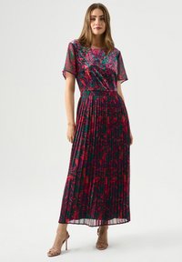 Plissiertes Maxikleid mit einem floralen Muster in rosa und grünen T�önen, kurzen Ärmeln und einer fließenden Silhouette. Tragen mit nude-farbenen Riemchenschuhen.