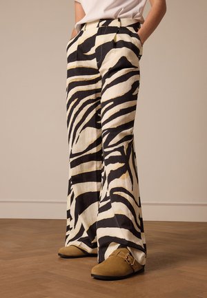Wijde broek in een zebra print, met zwart en crème kleuren en gouden accenten. Gemaakt van een lichte stof, met zijzakken.
