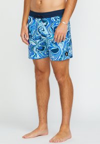 Shorts de bain bleus à motifs avec des designs abstraits tourbillonnants dans des nuances de bleu clair et foncé. Comprend une taille élastique et un détail de logo de la marque.