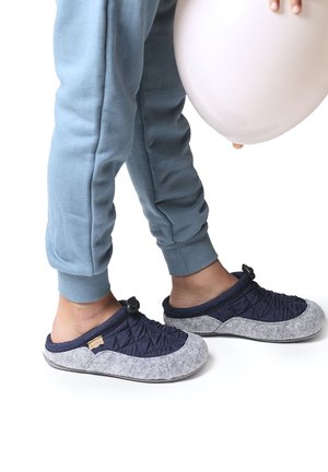 Marineblauwe en grijze instapslippers met een gewatteerd ontwerp en een zachte, viltachtige textuur. Voorzien van een togglesysteem voor aanpassing aan de bovenkant.
