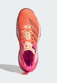 Sportliche Schuhe mit einem leuchtend orangefarbenen Textil-Obermaterial, pinken Akzenten und einer gepolsterten Sohle. Logo und Branding sind auf der Zunge und der Innensohle sichtbar.