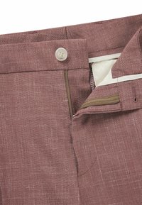 Bordeaux linnen broek met een knoopsluiting, rits en gestructureerde stof. Heeft een contrasterende binnenvoering.
