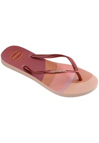Cioch din cauciuc roz și piersică cu talpă texturată, talpă plată și bretele împletite de culoare roșie închisă, având logo-ul "Havaianas".