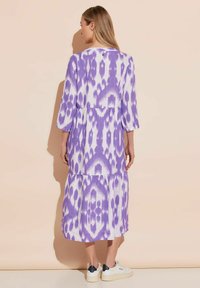 Vestido midi con estampado morado y blanco, mangas tres cuartos, diseño en capas, tejido texturizado y escote redondo.