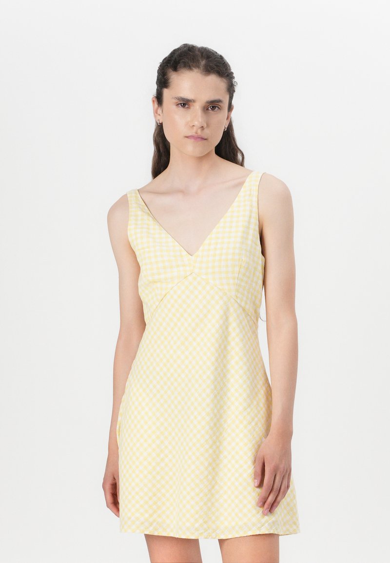 Yellow gingham dress with a V-neck, thin straps, and a fitted waist, featuring a slightly flared hem and lightweight fabric texture.