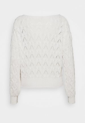 Kreemi-valge kudumiversioon, millel on teemantmuster, ribikätised ja -äär, lohvaka istuvuse ja laia kaelusega.