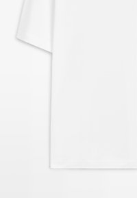 Weißes T-Shirt mit kurzen Ärmeln und einfachem Design, flach liegend vor weißem Hintergrund dargestellt.