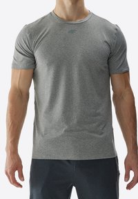 Camiseta atlética gris de manga corta y escote redondo, hecha de una tela suave y elástica; presenta un logotipo sutil en el pecho.