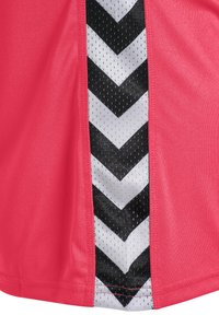Sporttop i stark rosa med en sidopanel med svart och vit chevronmönster, tillverkad av lätt och andningsbart material.