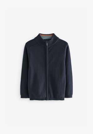 Sweat-shirt zippé bleu marine avec un col haut, des poignets côtelés et une texture lisse. Il présente un doublure intérieure contrastante au niveau du col.