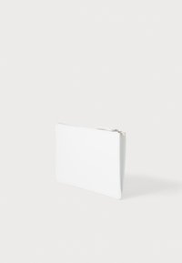 Pochette blanche zippée en matériau lisse et mat ; forme rectangulaire aux lignes épurées ; présente un design simple et minimaliste.