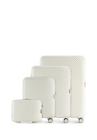 Vier witte hard-shell koffers in verschillende maten hebben een diagonale ribbelstructuur en rosegouden accenten, met wielen op de grotere stukken.