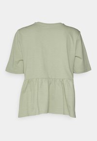 Světlá zelená krátká halenka s nařaseným peplum designem, jemnou texturou, kulatým výstřihem a hladkým lemem. Zadní pohled, jednobarevná bez vzorů.