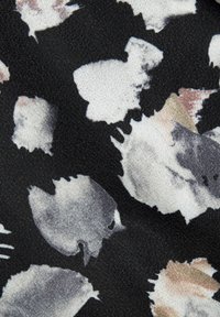 Musthave mustri mustriga kudum, milles on abstraktsed akvarellmustrid halli ja beeži toonides, kergelt tekstureeritud pinnaga.